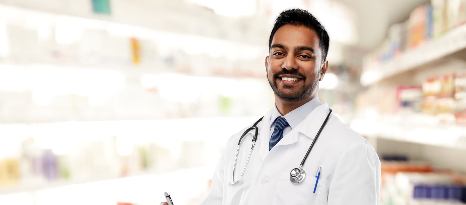 happy male pharmacist holding a pen