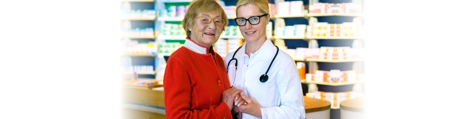 happy elderly woman holding hands with smiling female doctor